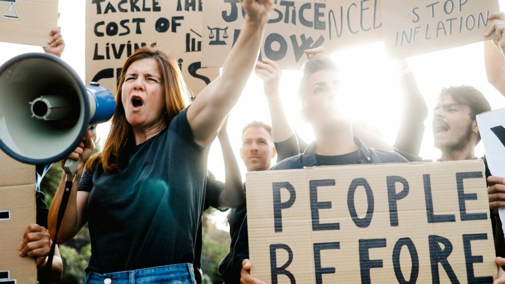 People protest financial crisis and inflation on the streets. Crowd marching for global economy