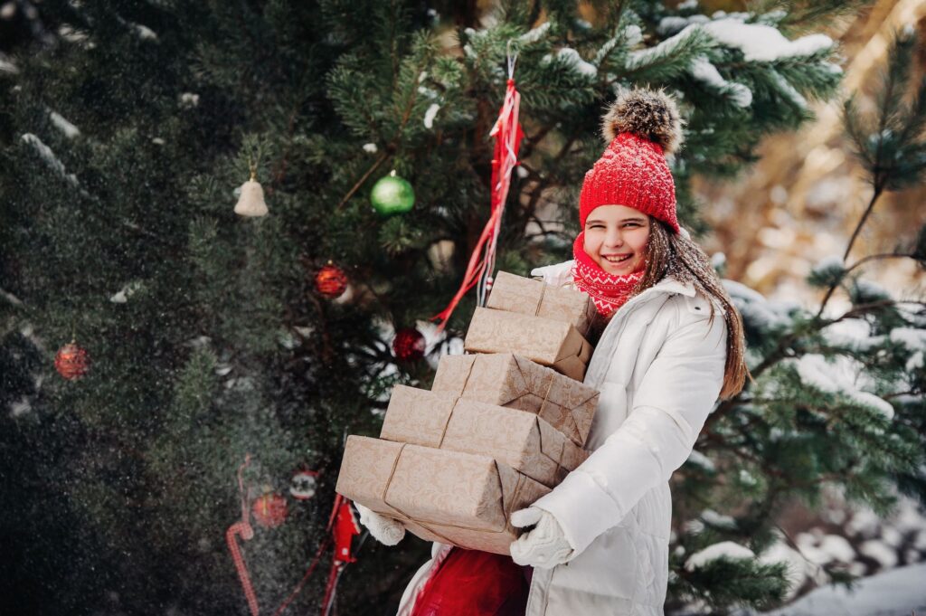 a girl with gifts in the winter on the street.a girl with a Christmas tree on a postcard