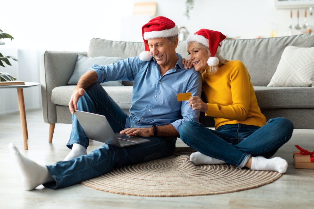 Senior Couple Buying Christmas Gifts Shopping Online Using Laptop Indoors