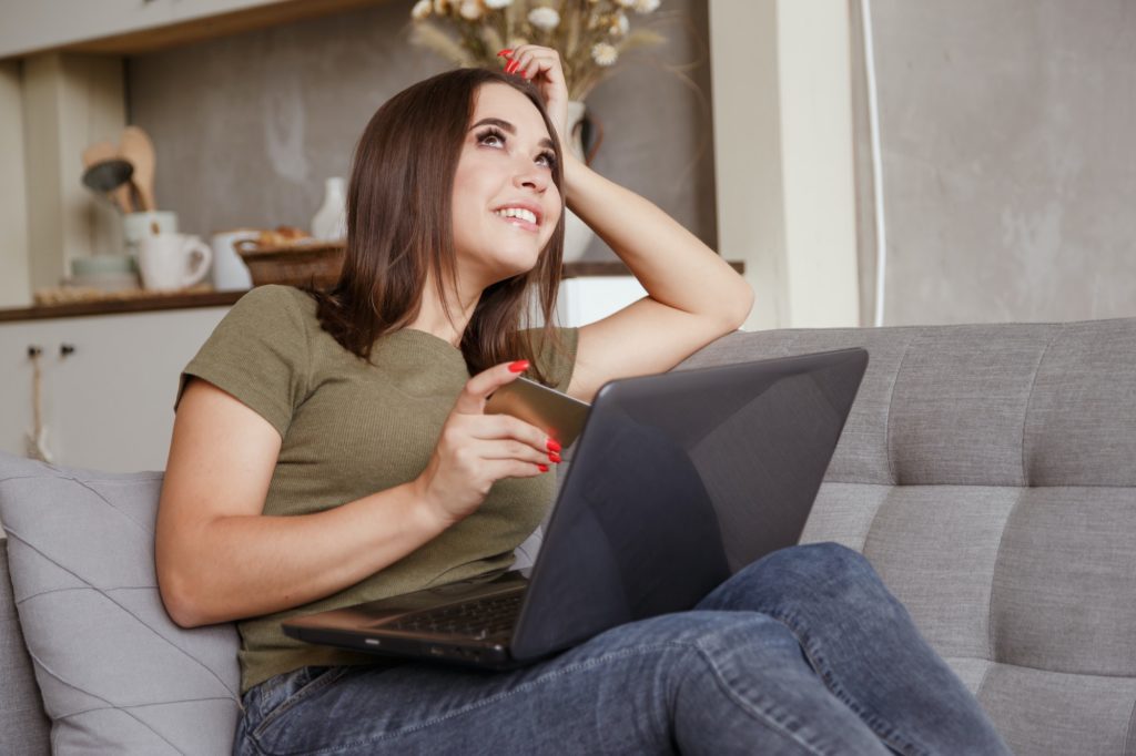 Young woman thinking what to do with a credit card