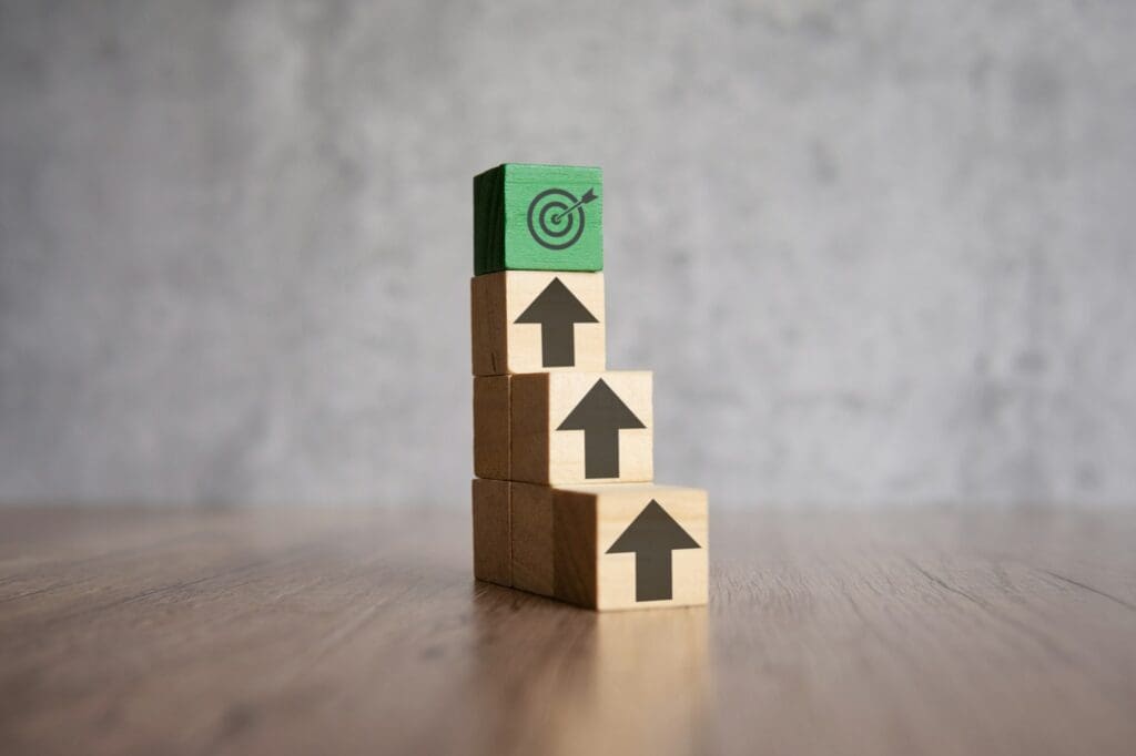 A stack of wooden blocks with arrows pointing upwards and target board.